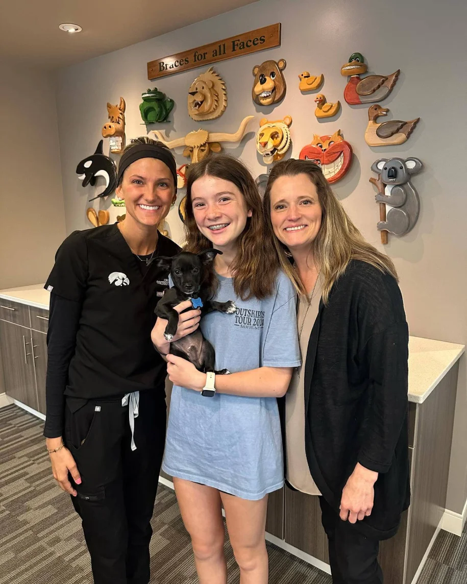 smiling patient and staff with puppy